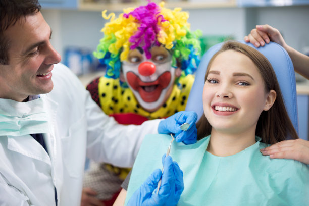 牙科诊所里有牙医和小丑的女孩图片下载