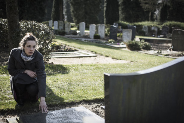 坐在坟墓前的女人素材图片