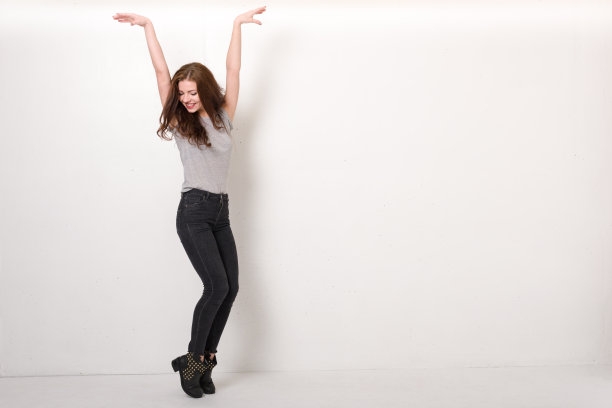 年轻女子举起双手踮起脚尖图片下载