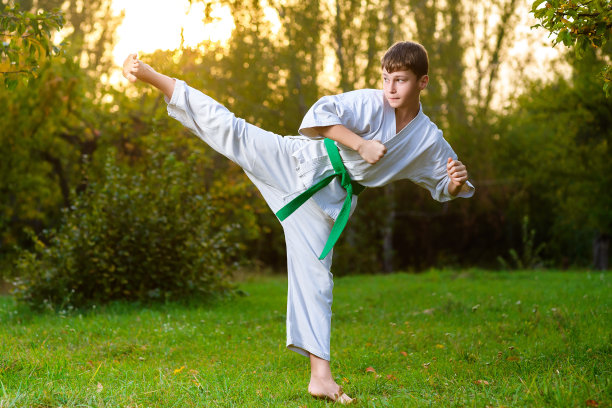 穿着白色和服的男孩在夏季训练空手道练习图片下载