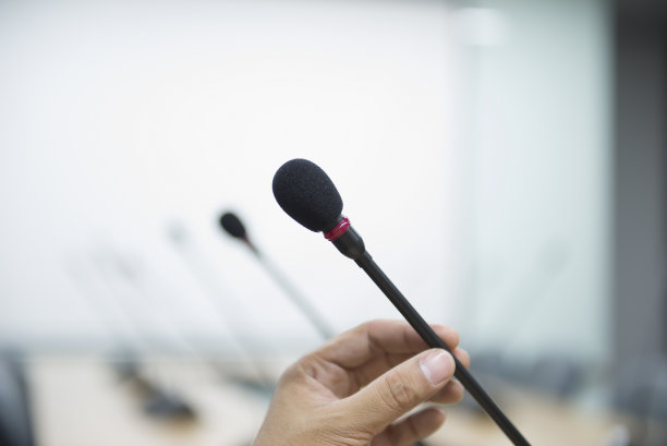 一个手持商务会议麦克风的手的特写图片下载