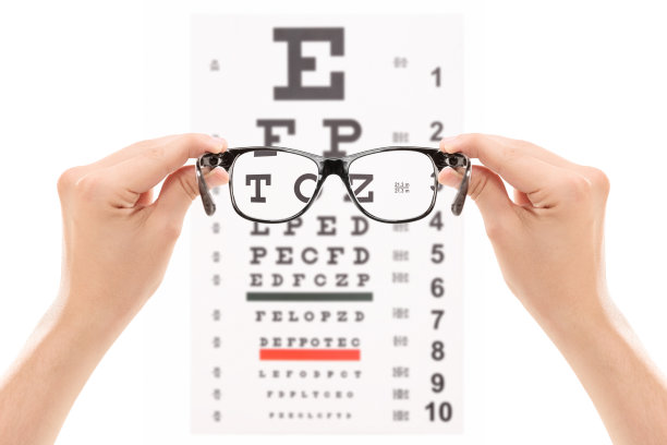 手拿眼镜放在视力表前图片下载