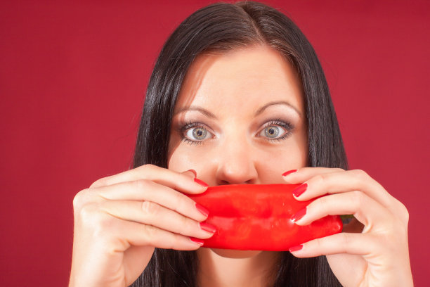 女模特拿着辣椒在脸上图片下载