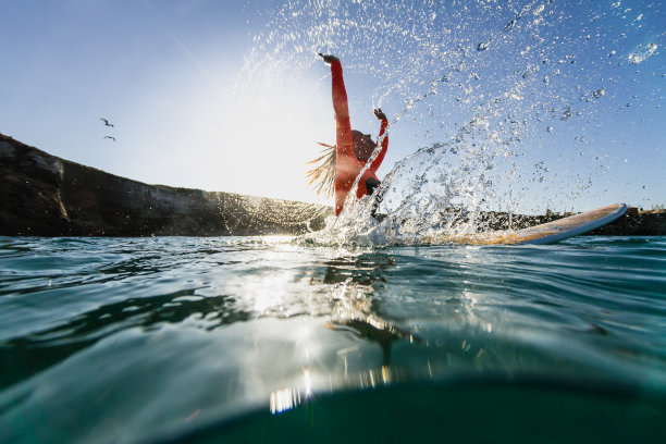 女人坐在冲浪板上溅起水花图片下载