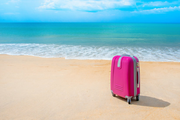 手提箱在阳光明媚的海滩图片下载