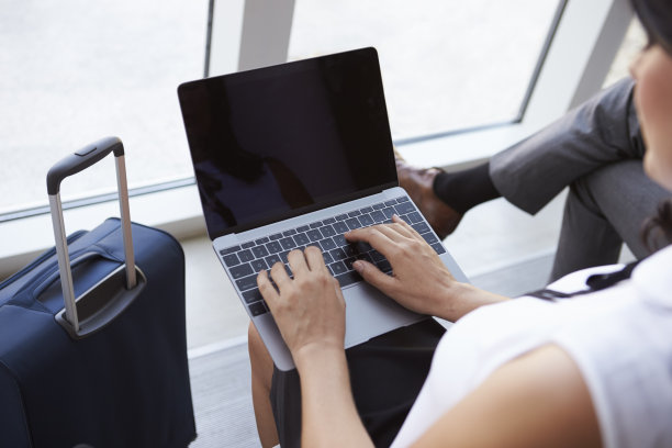 商务女性在机场候机室使用笔记本电脑图片下载