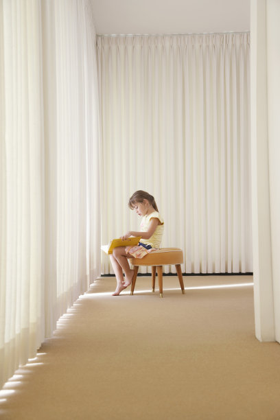 坐在凳子上看书的小女孩图片下载