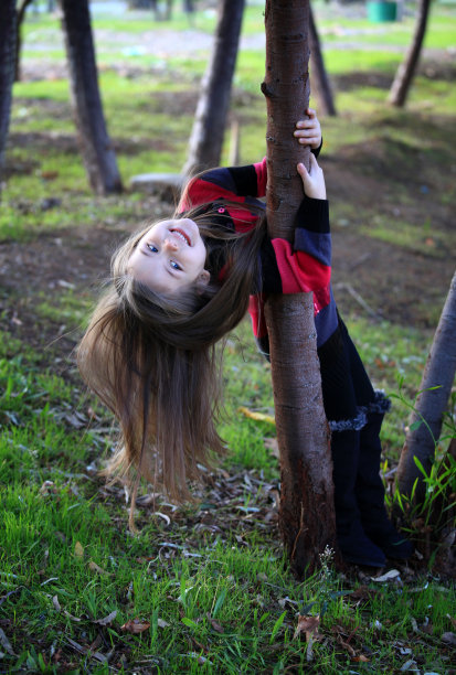 小女孩躲在一根树干后面图片下载
