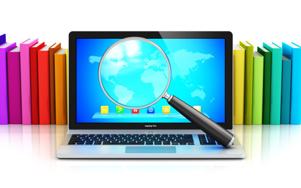 笔记本电脑和放大镜摆在一排彩色书前素材图片
