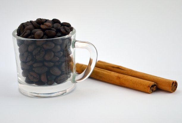 白色背景下的咖啡豆和肉桂图片下载