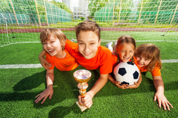 快乐的孩子们躺在草地上，拿着金杯图片下载