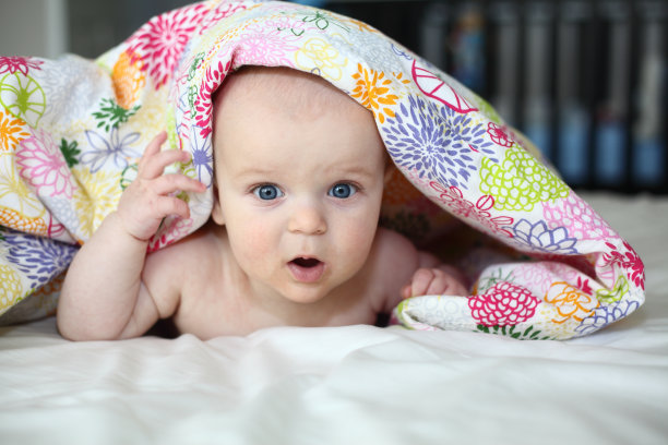 躲猫猫——婴儿从毯子下面向外偷看图片下载