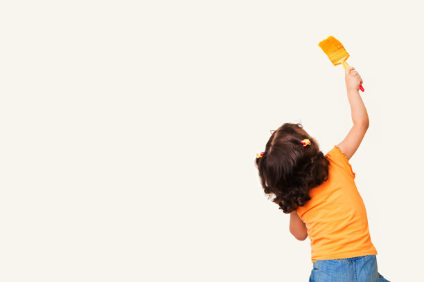 小女孩在墙上画东西做背景图片下载