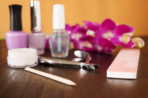 指甲和兰花放在一张木桌上图片下载