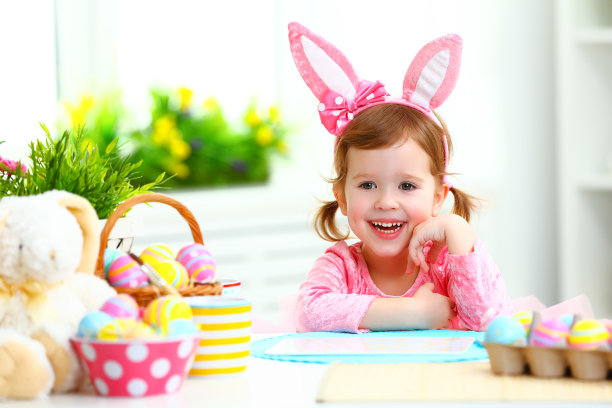 复活节。快乐的小女孩兔子耳朵和彩色的鸡蛋图片下载