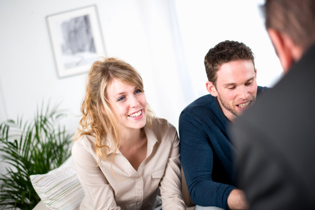 一对快乐的年轻夫妇和一个顾问销售员图片下载