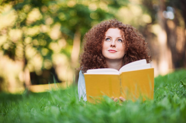 美丽的女孩在公园里读书图片下载