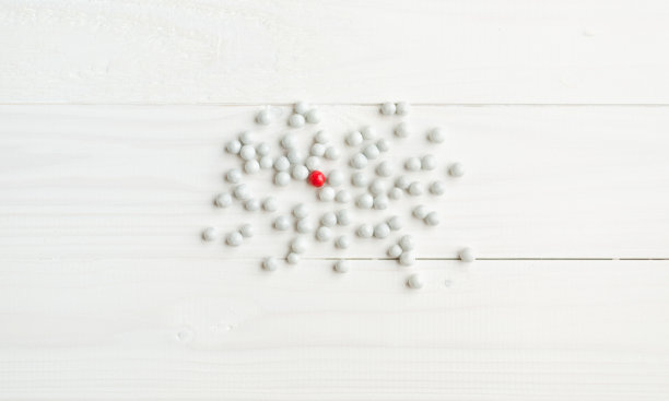 白色糖果中的红色糖果。社会差异的概念图片下载