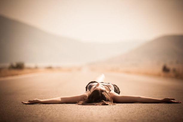 一个女人躺在荒无人烟的高速公路上图片下载