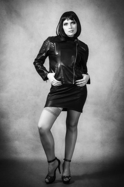 美丽的黑发摆姿势在皮夹克和迷你裙图片下载