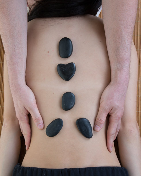 一位年轻女士正在水疗中心做石头按摩。图片下载