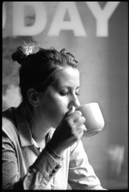 咖啡城市生活方式的女人坐在室内喝咖啡。电影的照片。图片下载