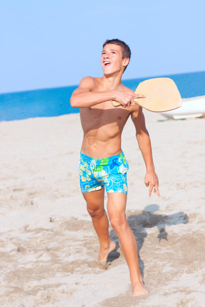 男孩在沙滩上打网球图片下载