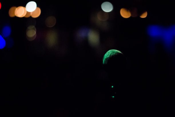 麦克风的剪影与模糊的灯光在背景图片下载