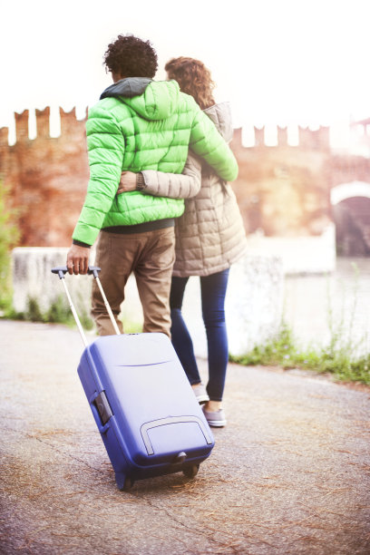 一对带着行李箱在城里散步的游客夫妇图片下载