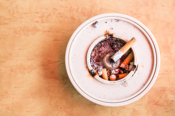 上方的烟头烟灰缸放在桌子上图片下载