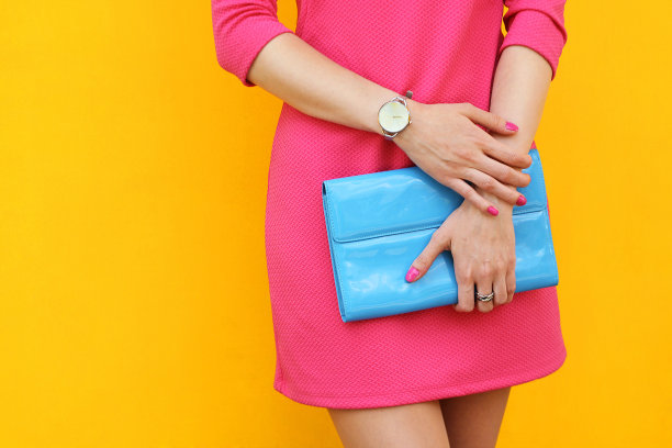 户外时髦的女孩靠近黄色的街道墙。时髦的粉红色连衣裙图片下载