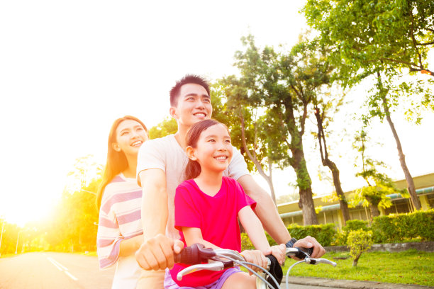 快乐的亚洲家庭在公园里玩自行车素材图片