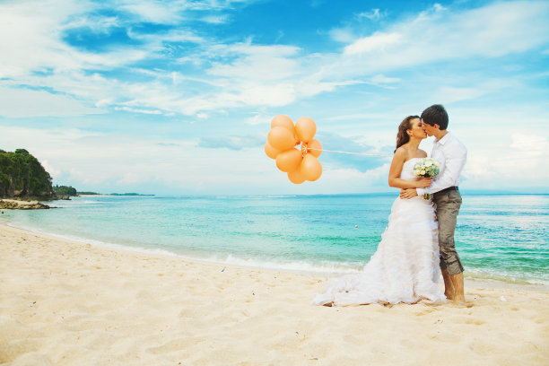 新娘和新郎在海滩上接吻素材图片