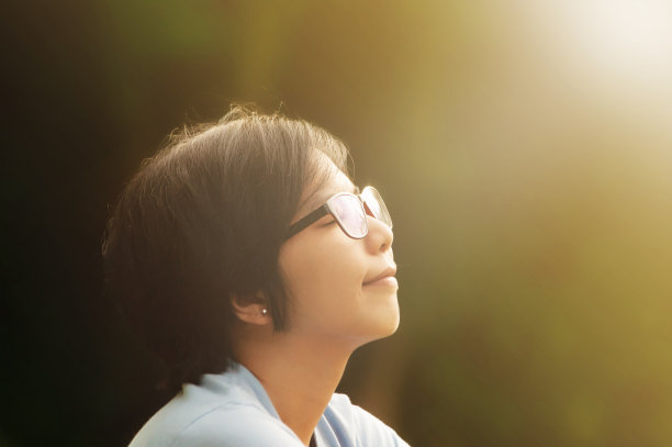 亚洲女性坐在公园里的特写。图片下载