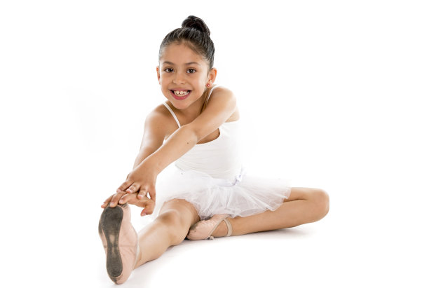 年轻可爱的小女孩芭蕾舞演员伸展在白色的背景图片下载