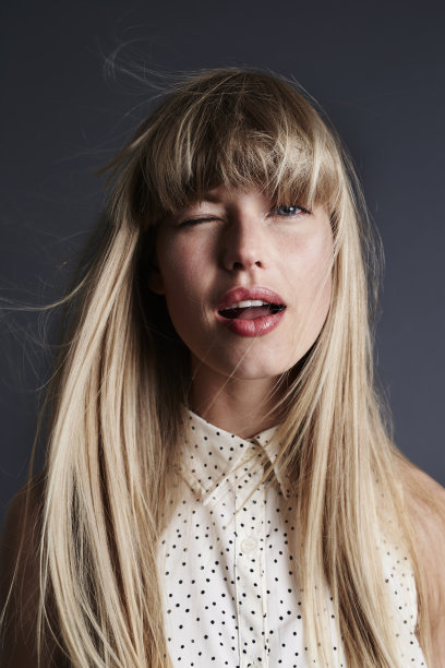 金发美女在灰色的画室，肖像图片下载