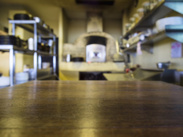 木质桌子的顶部与模糊的厨房餐厅背景素材图片