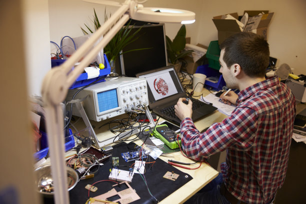 电气工程师在工作台上测试部件图片下载