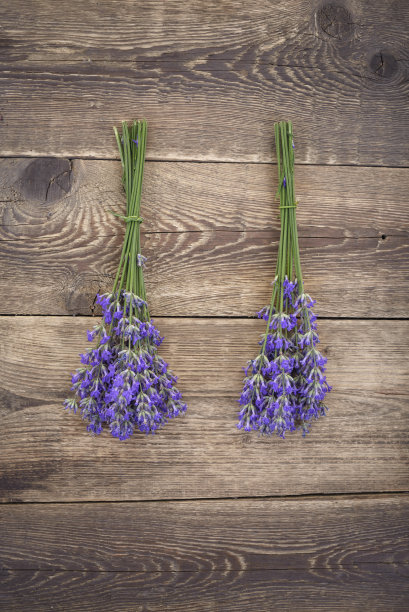 在质朴的木制背景上放着几束薰衣草图片下载