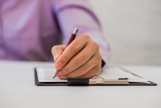 一个商人用钢笔在纸上写字的照片图片下载