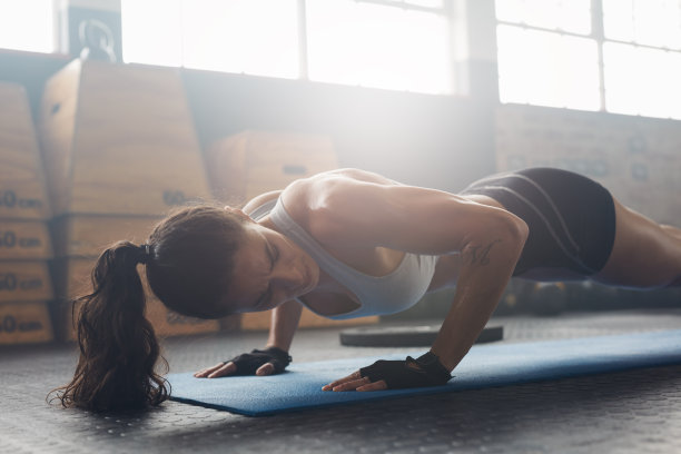 女性在健身房健身垫上锻炼图片下载