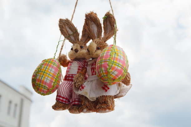 两个摇摆着彩蛋的复活节兔子图片下载