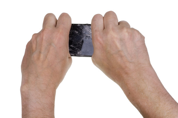 这位手多毛、神经紧张的老人把坏掉的手机掰了又扭。孤立的影棚拍摄图片下载