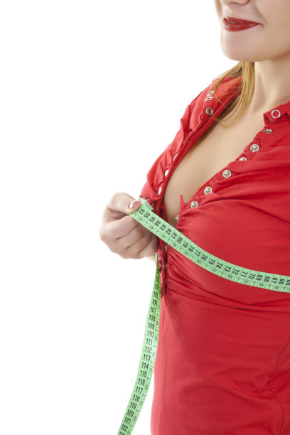 美丽的女人正在量她的胸部图片下载