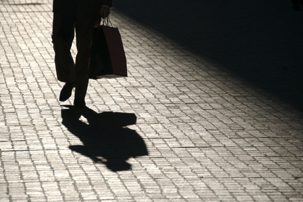 难以辨认的影子男人带着购物袋走在户外图片下载