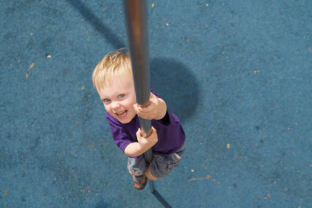男孩从操场上的火线杆上下来图片下载