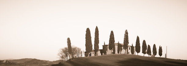 托斯卡纳山上的老农场，日落时分有柏树图片下载