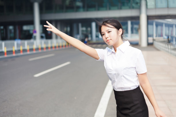 年轻的女商人在机场打出租车图片下载