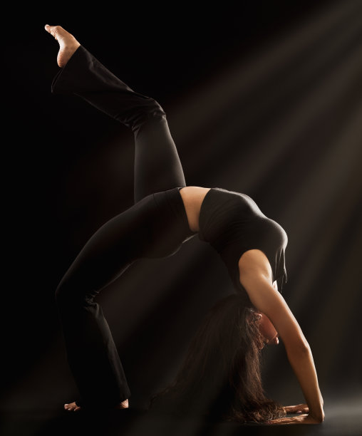 美丽的年轻女子表演充分后屈与腿伸展图片下载