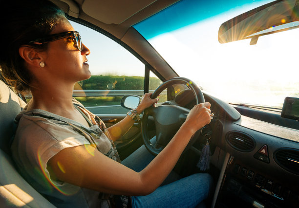 一名年轻女子一边开车一边看后视镜图片下载